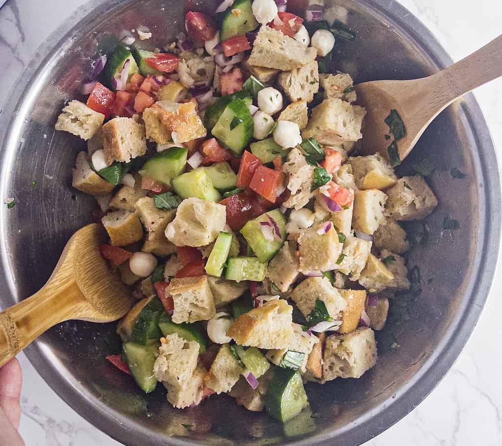 Panzanella salad in bowl with serving spoons