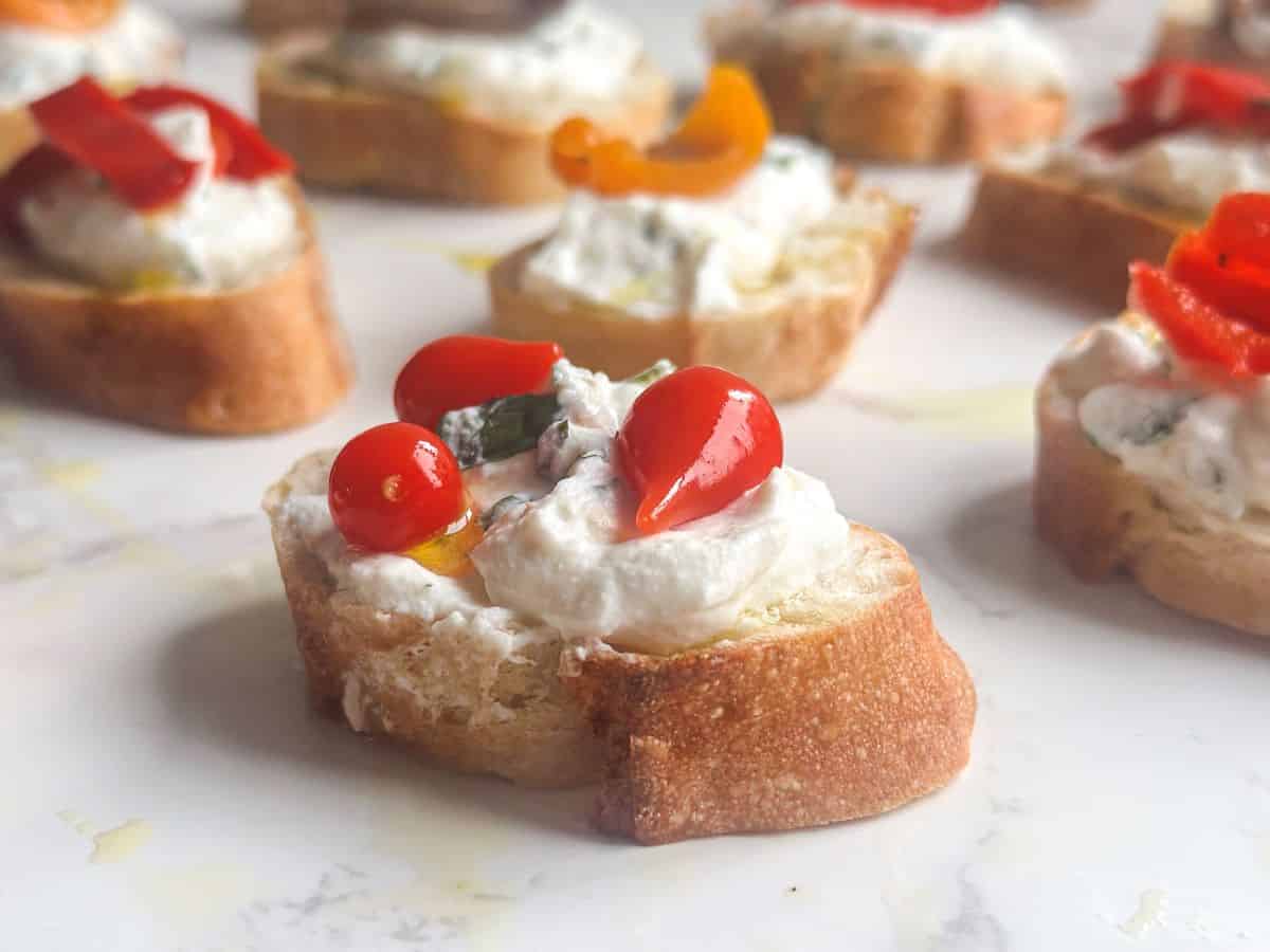 Whipped ricotta and fresh herb crostini with Peruvian pearl peppers.