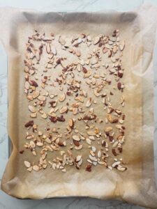 Toasted sliced almonds on a baking sheet with parchment paper.