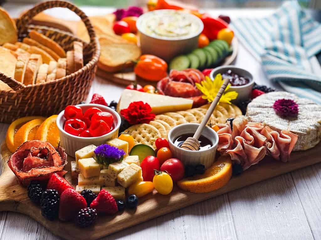 Summer charcuterie boards with a basket of bread.