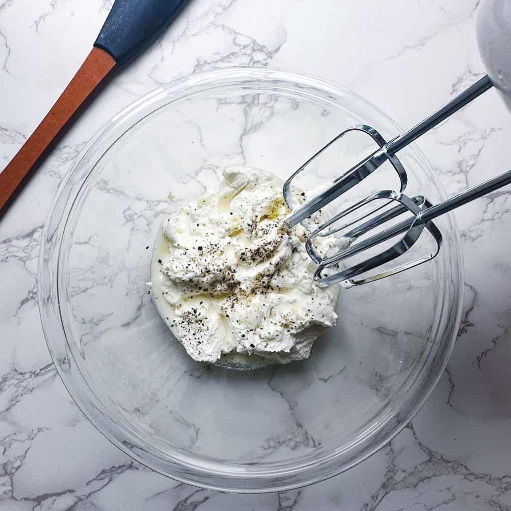 Ricotta dip ingredients in a bowl with beaters.