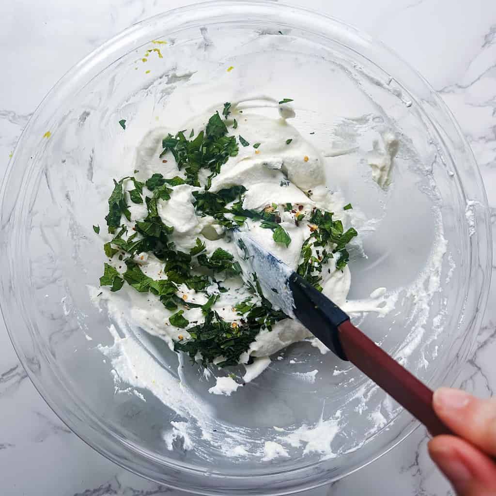 Ricotta dip ingredients in a bowl being stirred with a spatula.
