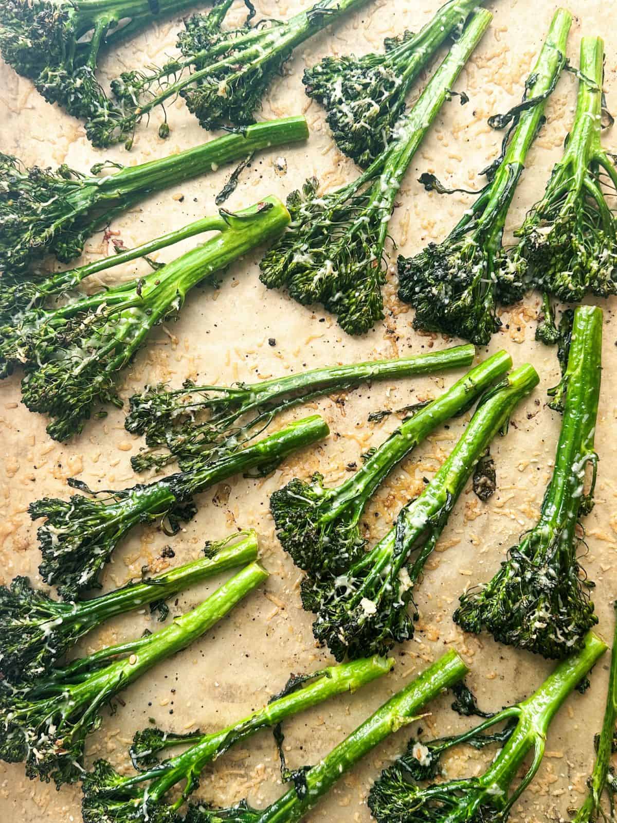 Charred broccolini on parchment paper with garlic and parmesan.