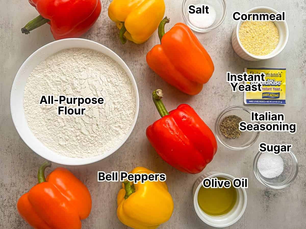 Ingredients for making fall focaccia including flour, cornmeal, bell peppers, olive oil, yeast, salt, and seasonings.