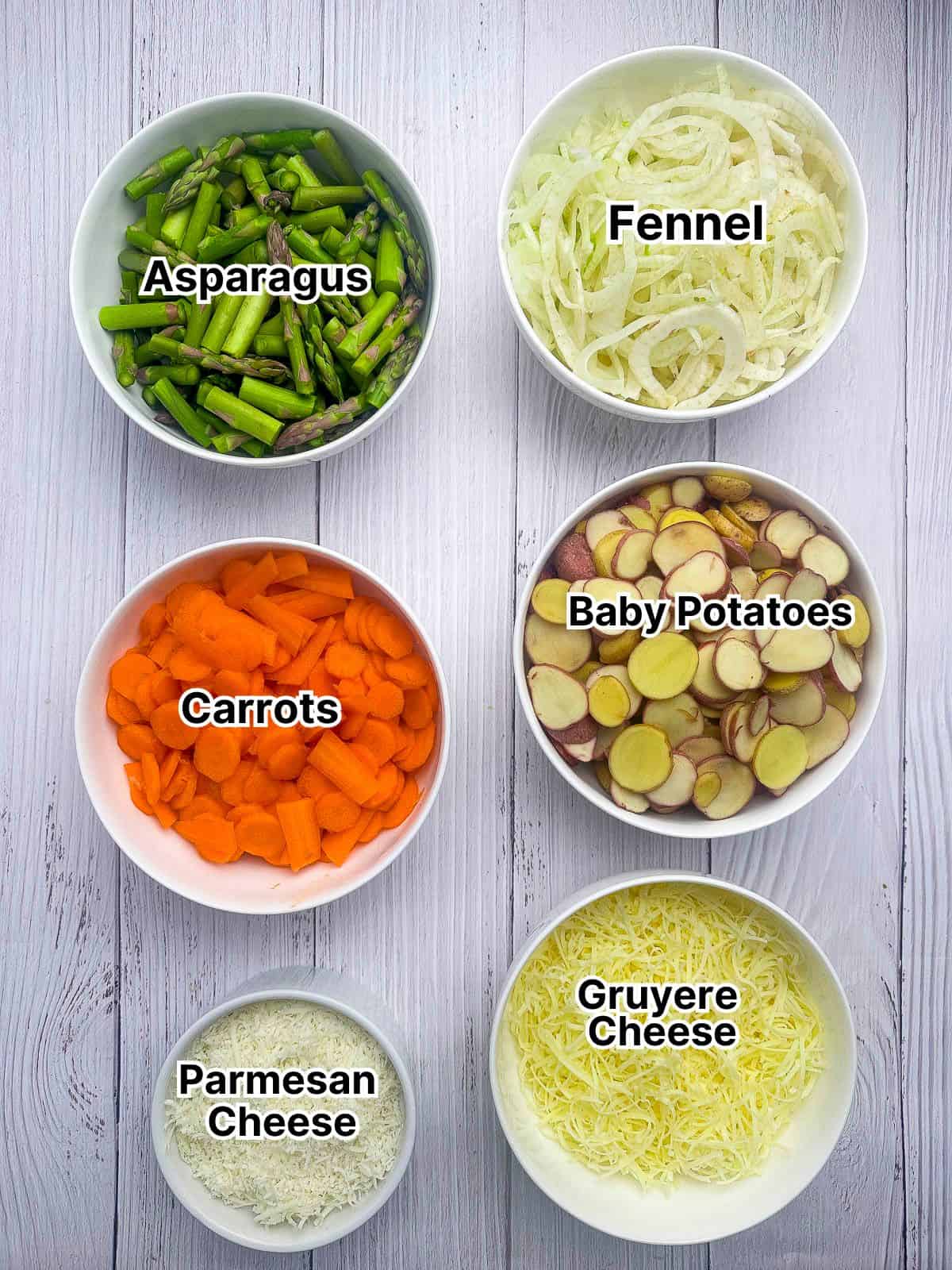 Ingredients for spring vegetable au gratin laid out in small bowls.