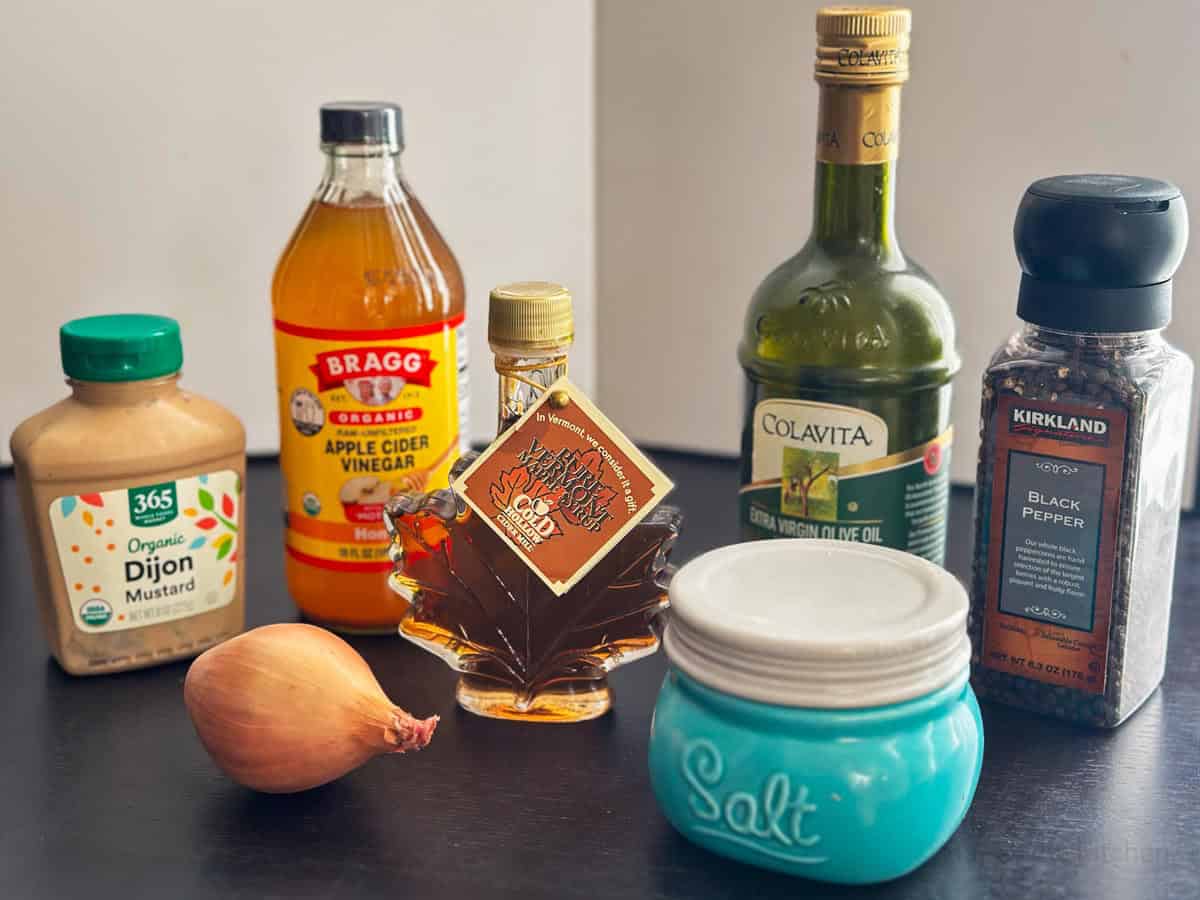 A shallot, apple cider vinegar, olive oil, mustard, maple syrup, black pepper, and salt for homemade apple cider vinaigrette.