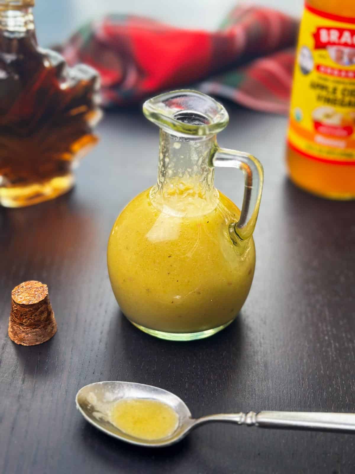 Sweet and tangy apple cider vinaigrette dressing in a small glass jar, perfect for salads or marinades.