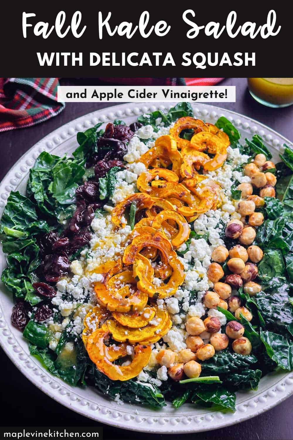Fresh fall kale salad with delicata squash, hazelnuts, goat cheese, and apple cider vinaigrette on a decorative platter.