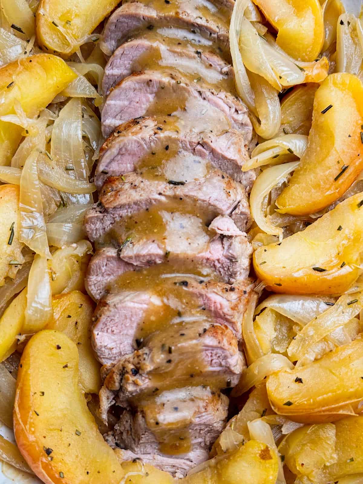 Roast pork tenderloin slices with roasted apples and caramelized onions.